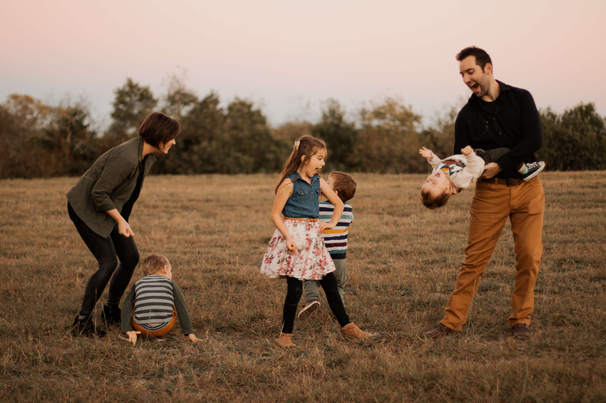 Photo of Alex and his family in a field at sunset.